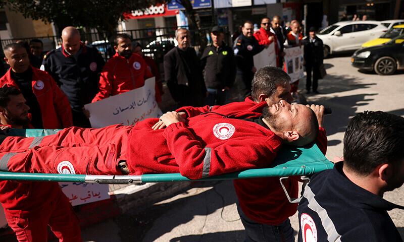 A Palestinian paramedic acting as a war casualty is carried on a stretcher by his colleagues from the Palestinian Red Crescent Society (PRCS) during a protest to denounce the death of PRCS personnel in the ongoing Israeli bombardment in Gaza, in the occupied  West Bank city of Hebron on February 11, 2024.&mdash;AFP