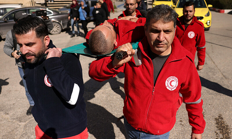 A Palestinian paramedic acting as a war casualty is carried on a stretcher by his colleagues from the Palestinian Red Crescent Society (PRCS) during a protest to denounce the death of PRCS personnel in the ongoing Israeli bombardment in Gaza, in the occupied  West Bank city of Hebron on February 11, 2024.&mdash;AFP