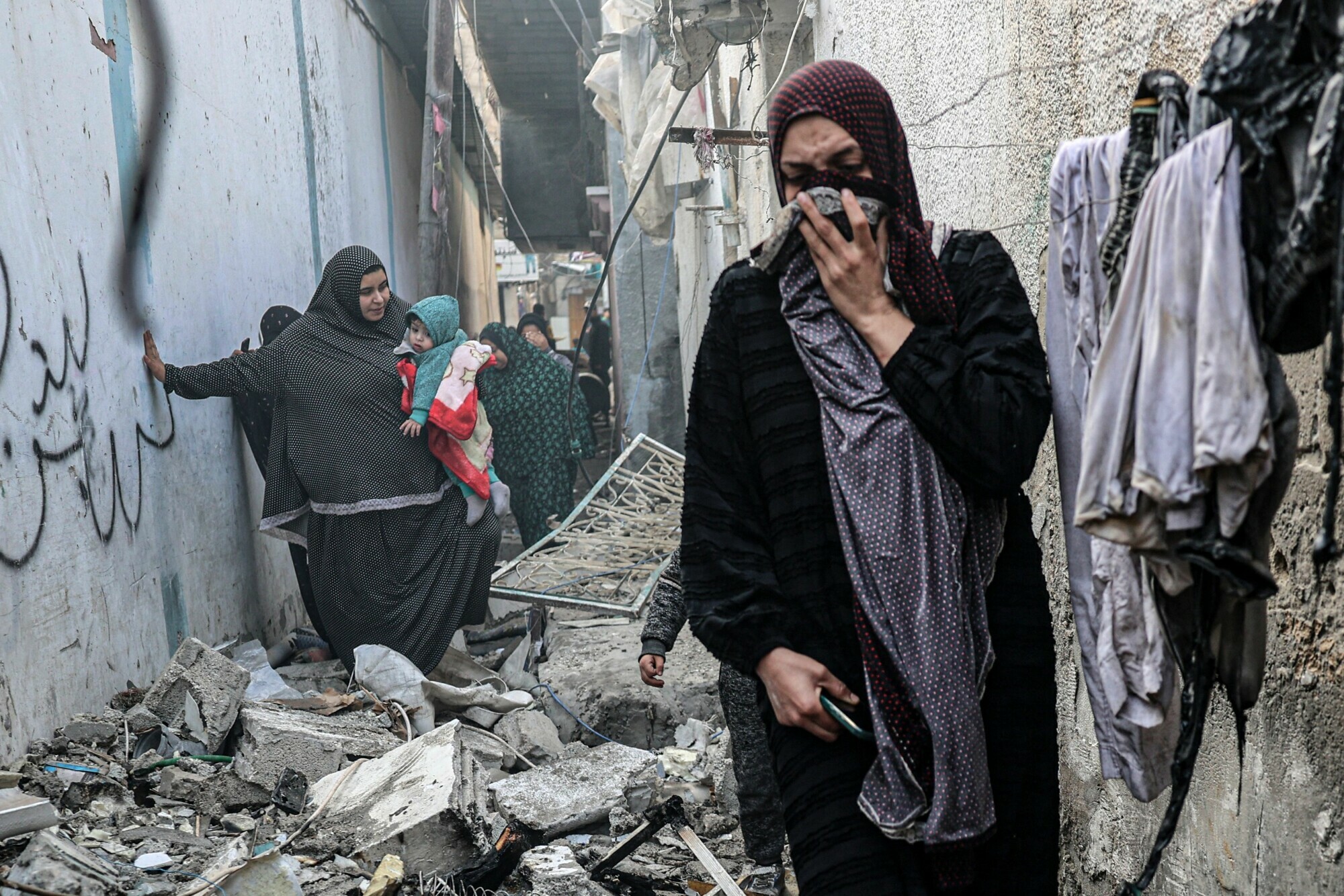People find their way through a rubble-covered alley, following overnight Israeli bombardment in Rafah in the southern Gaza Strip on February 25. &mdash; AFP