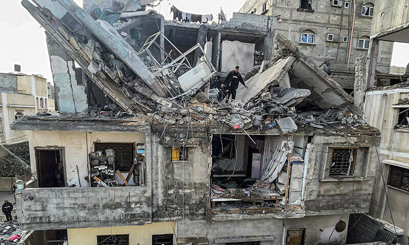 Palestinians search the rubble of their house which was destroyed in an overnight Israeli air strike in the Rafah refugee camp in the southern Gaza Strip on February 27, 2024 &mdash; AFP