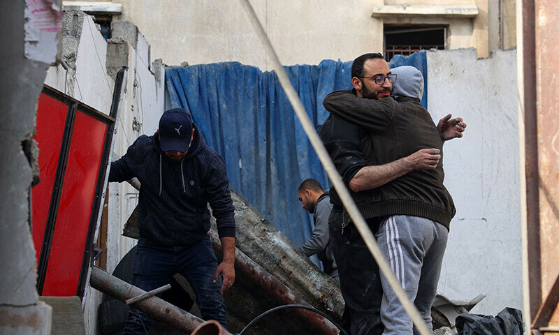Palestinians hug each other while searching the rubble of their house following an overnight Israeli air strike in the Rafah refugee camp in the southern Gaza Strip on February 27, 2024 &mdash; AFP