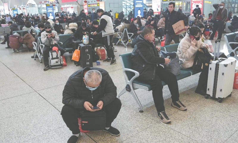 People wait for trains at a station in Shijiazhuang, on Tuesday.&mdash;AFP