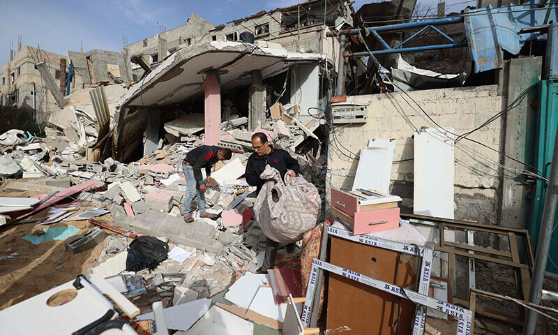 A Palestinian man carries items recovered from debris following Israeli bombardment in Rafah, in the southern Gaza Strip, on March 27, 2024 &mdash; AFP