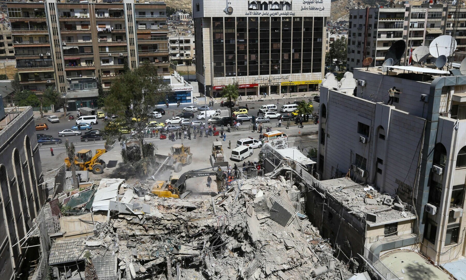  Rescue workers search in the rubble of a building annexed to the Iranian embassy a day after an air strike in Damascus on April 2. &mdash; AFP 