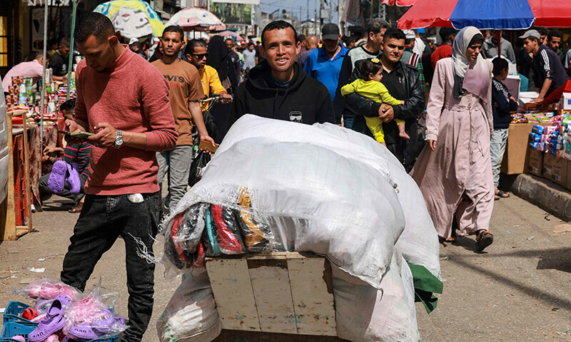 A man transports clothing for sale in a market, ahead of Eidul Fitr, in Rafah in the southern Gaza Strip on April 5, 2024.&mdash;AFP
