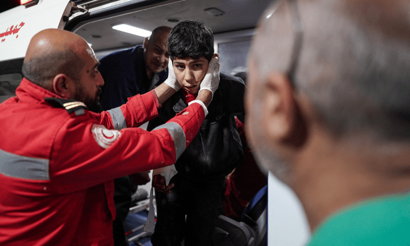  A paramedic helps an injured boy out of an ambulance outside the Al-Aqsa Martyrs Hospital in Deir al-Balah, central Gaza Strip, on April 9. &mdash; AFP 
