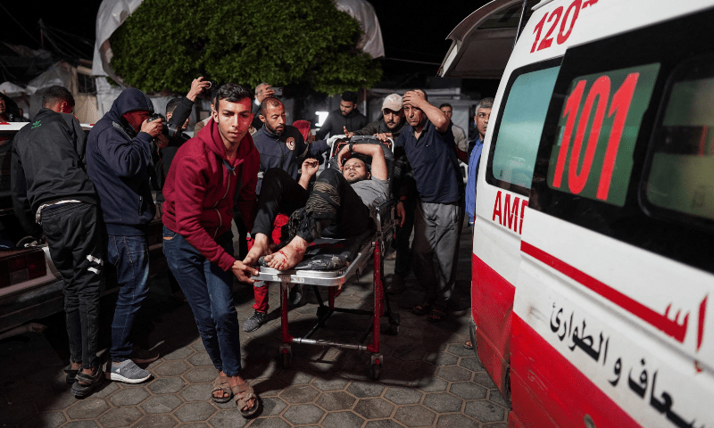  People bring an injured man on a stretcher to the Al-Aqsa Martyrs Hospital in Deir al-Balah, central Gaza Strip, on April 9. &mdash; AFP 