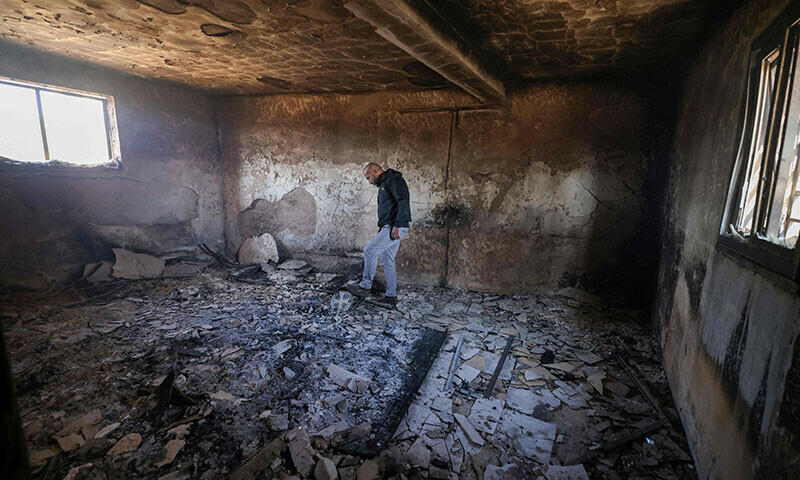 A Palestinian inspects the damage to a home in the village of Mughayir in the Israeli-occupied West Bank on April 13, 2024. &mdash;  AFP
