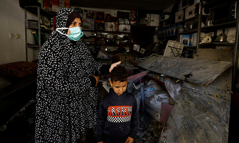 A Palestinian woman and child react at the site of an Israeli strike on a house in Rafah, in the southern Gaza Strip on April 17, 2024 &mdash; Reuters