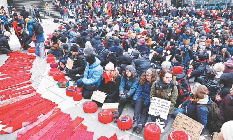 Stockholm: Women with red scarves gather at Sergels Torg Square during a rally to demonstrate for the 1.5 degrees Celsius warming limit.&mdash;AFP