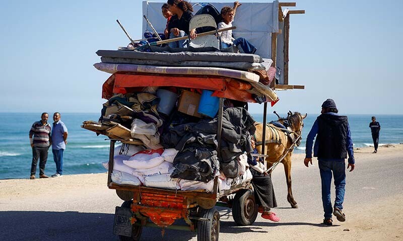 Palestinians travel in an animal-drawn cart as they flee Rafah amidst an Israeli ground and air operation in the southern Gaza city on May 9. &mdash; Reuters