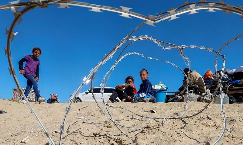 Palestinians sit to next to their belongings as people flee Rafah after Israeli forces launched a ground and air operation in the southern Gaza city on May 9 &mdash; Reuters