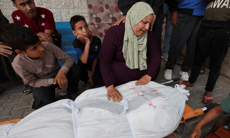  Mourners react next to the body of a Palestinian killed in Israeli strikes at Al-Aqsa hospital, in Deir Al-Balah, in the central Gaza Strip on May 12. &mdash; Reuters 