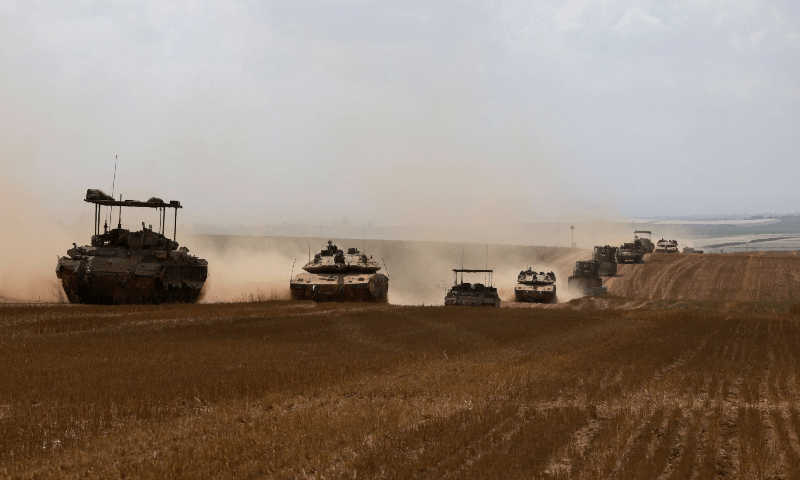  Israeli military vehicles roll near the border with the Gaza Strip on May 12, 2024. &mdash; AFP 