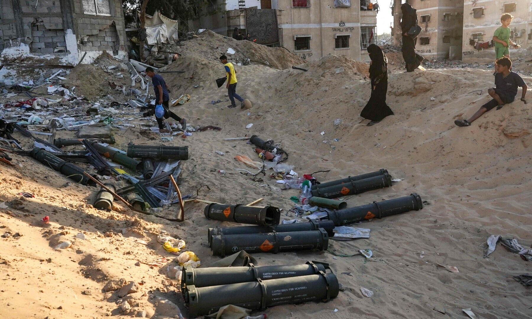  Palestinian children gather empty ammunition containers in Khan Younis in the southern Gaza Strip on May 16. &mdash; AFP 