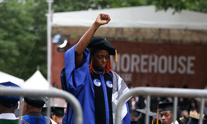 A woman stands with her back turned and holding up her fist during a speech by US President Joe Biden, during a Morehouse College commencement ceremony in Atlanta, Georgia, US, May 19, 2024. &mdash; Reuters