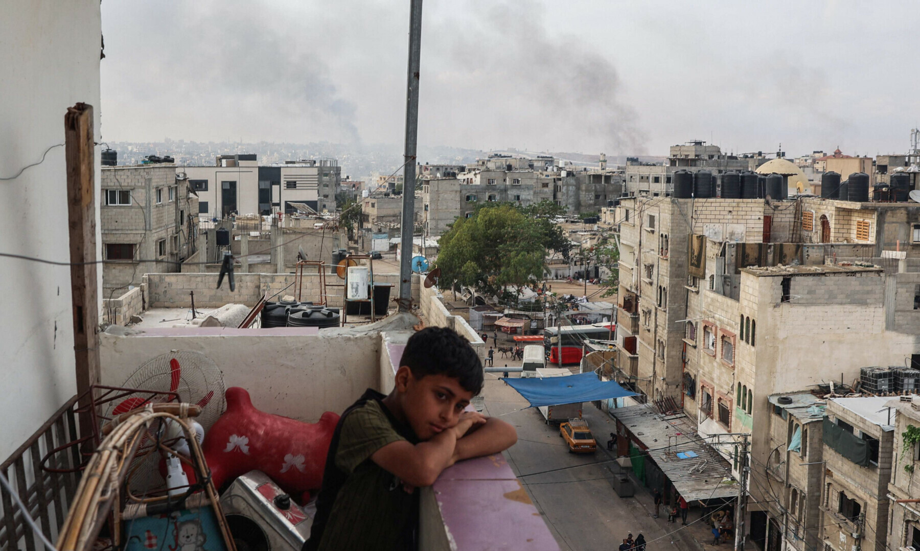  A boy stands on a balcony with a view of billowing smoke due to renewed Israeli strikes in Rafah city in the southern Gaza Strip on May 28, 2024. &mdash; AFP 