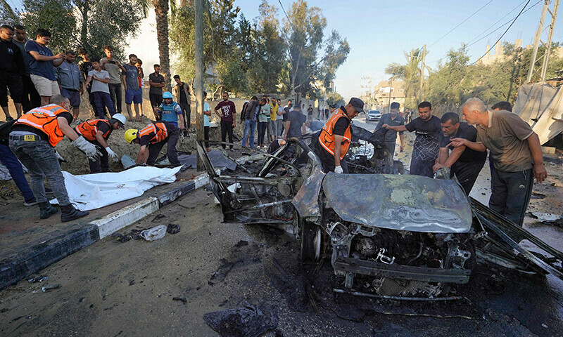 Palestinians check the site of an Israeli strike on a vehicle in the central Gaza Strip on May 31. &mdash; AFP