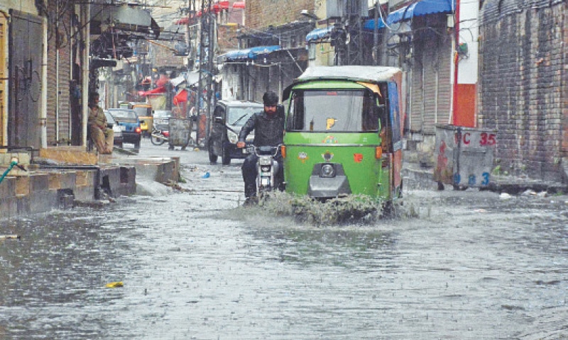 Vehicles travel through rainwater accumulated on Imambara Road in Rawalpindi following early morning rain on Friday. &mdash; Onlilne