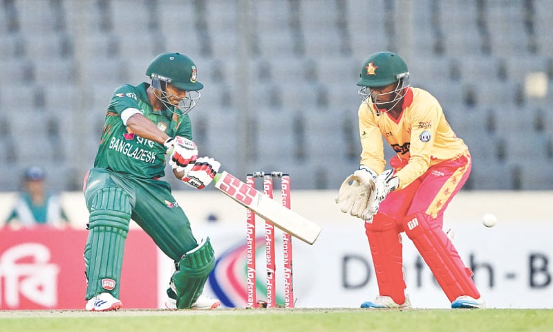 DHAKA: Bangladesh&rsquo;s Tanzid Hasan (L) plays a shot as Zimbabwe&rsquo;s wicket-keeper Clive Madande looks on during the fourth Twenty20 International at the at Sher-e-Bangla National Cricket Stadium on Friday.&mdash;AFP