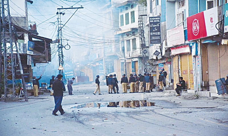 POLICEMEN stand at the troubled Shah Sultan area of Muzaffarabad after street clashes with protesters, on Saturday.—Photo by the writer POLICEMEN stand at the troubled Shah Sultan area of Muzaffarabad after street clashes with protesters, on Saturday.—Photo by the writer
