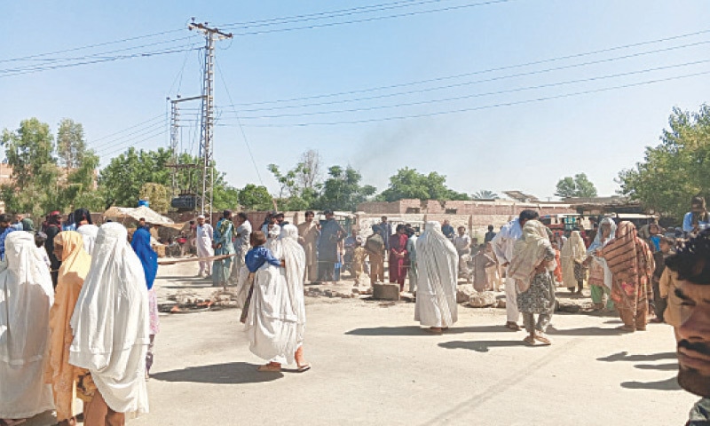 Consumers including burqa-clad women stage a protest outside Pesco grid station in Shorkot area of Dera Ismail Khan on Tuesday. &mdash; Dawn