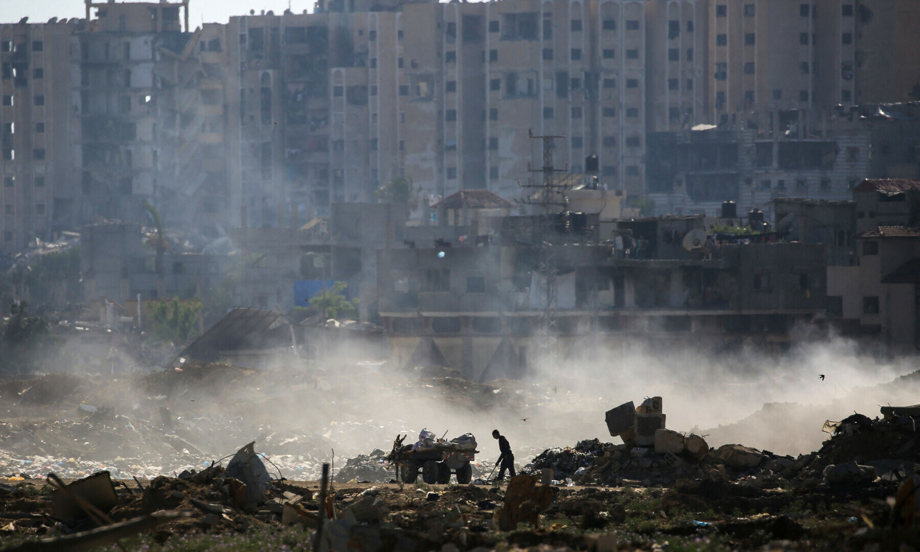  A Palestinian man slavages items from a waste dump atop building rubble at al-Bureij camp in the central Gaza Strip on June 2, 2024 &mdash; AFP 