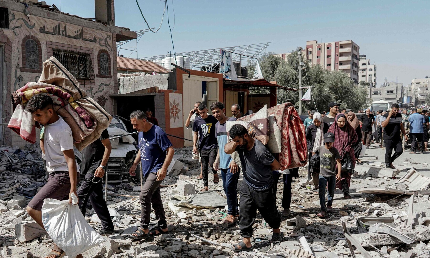  Palestinians evacuate with their belongings following an operation by the Israeli Special Forces in the Nuseirat camp, in the central Gaza Strip on June 8, 2024. &mdash; AFP 