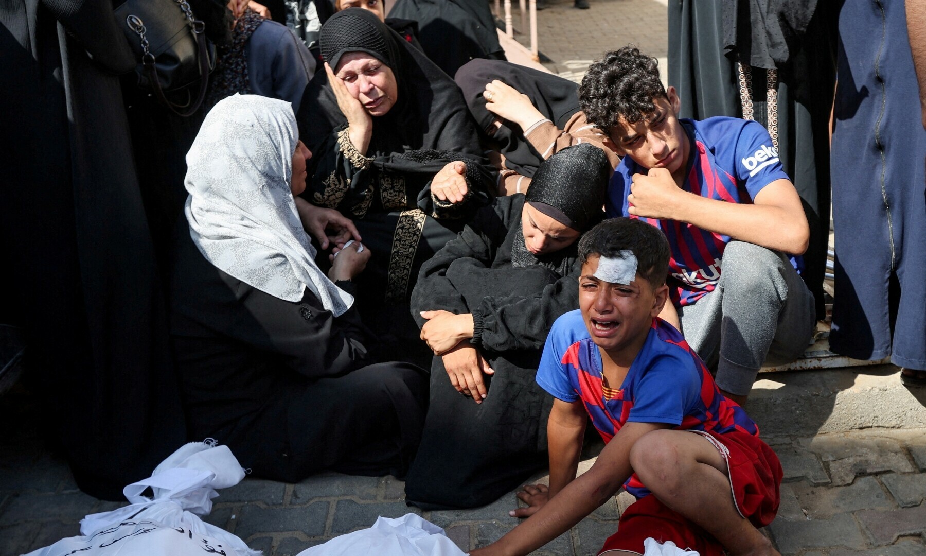  Mourners gather next to the bodies of Palestinians killed in Israeli strikes, at Al-Aqsa hospital in Deir Al-Balah, in the central Gaza Strip on June 18, 2024. &mdash; Reuters 