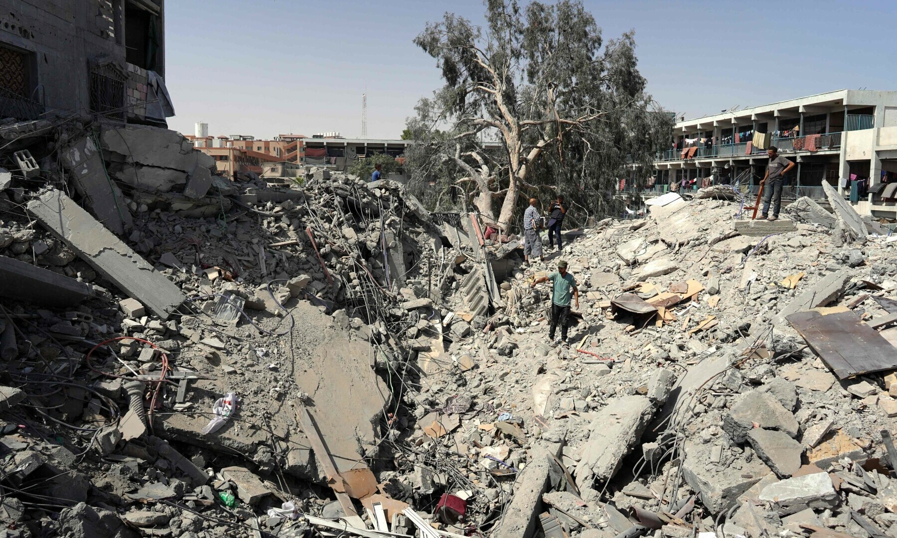 Palestinians check the destruction after an Israel strike the previous day on a five-story building next to a school sheltering displaced people, in Khan Younis in the southern Gaza Strip on July 4, 2024. — AFP