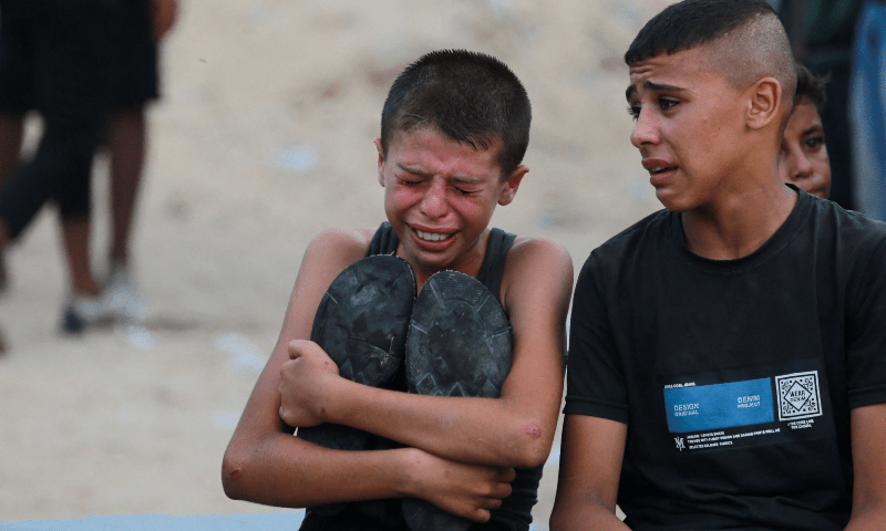  Shams, the son of 47-year-old Ahmad Abu Taha hugs his late father&rsquo;s shoes as he weeps while killed members of the Abu Taha family are brought for burial, outside Nasser hospital in Khan Younis, following Israeli bombardment of the southern Gaza Strip city on July 22. &mdash; AFP 