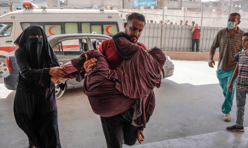  A man carries a woman into the Nasser hospital, where the injured and dead arrive following the Israeli targeting the southeastern district of Khan Younis, in the southern Gaza Strip, on July 25. &mdash; AFP 