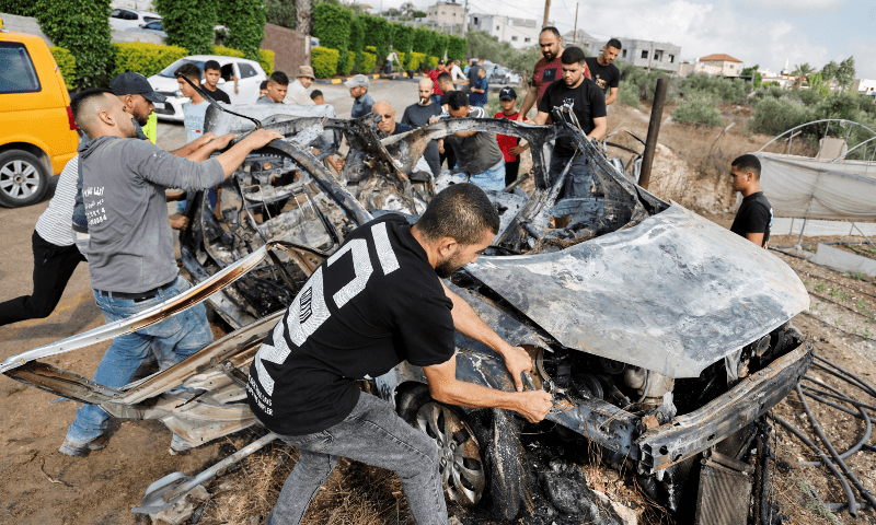  Palestinians inspect a vehicle damaged in an Israeli airstrike, in Zeita, near Tulkarm, in the Israel-occupied West Bank on Aug 3, 2024. &mdash; Reuters 