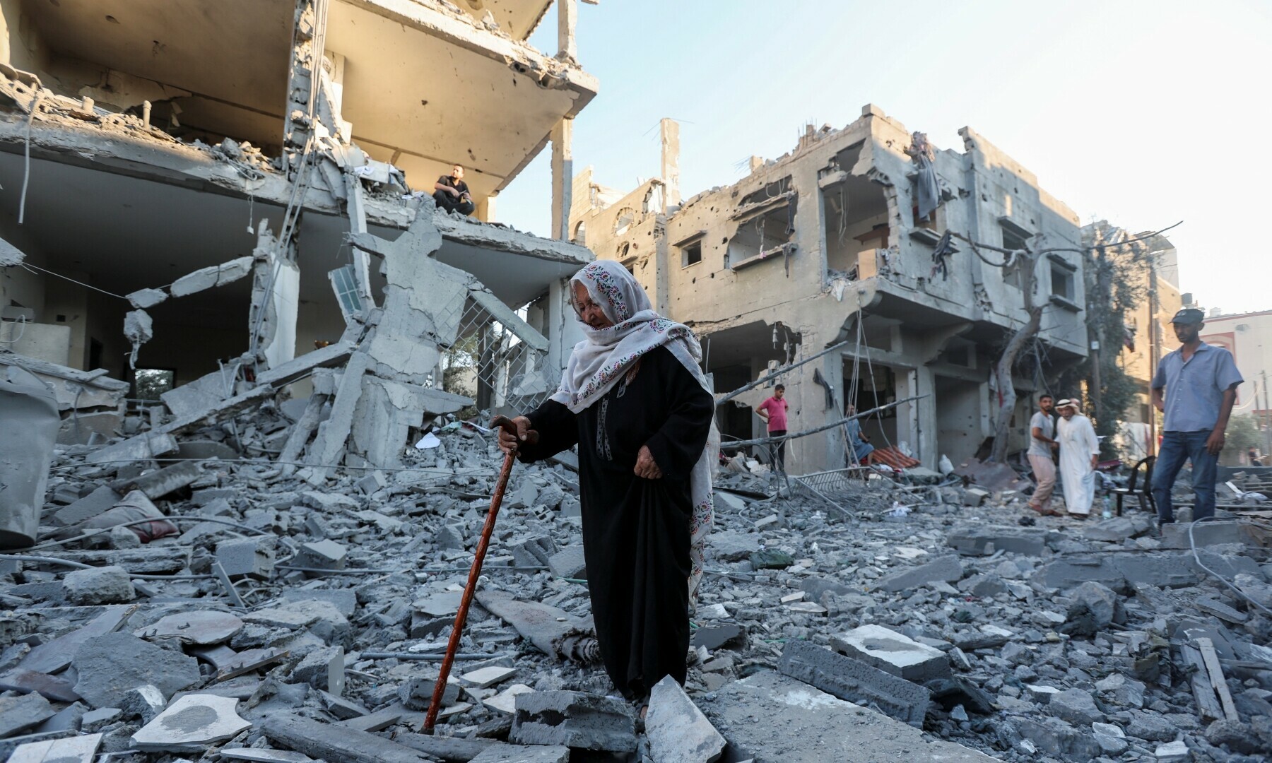  A Palestinian woman walks past destroyed houses at the site of an Israeli strike in Deir Al-Balah in the central Gaza Strip on Aug 7, 2024. &mdash; Reuters 
