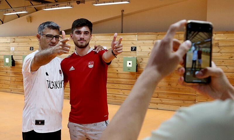 Turkish shooter Yusuf Dikec, who won the silver in the mixed team 10-meter air pistol event in the Paris 2024 Olympics combined with Sevval Ilayda Tarhan, poses with a fan following a training in Ankara, Turkiye on Aug 8, 2024. — Reuters