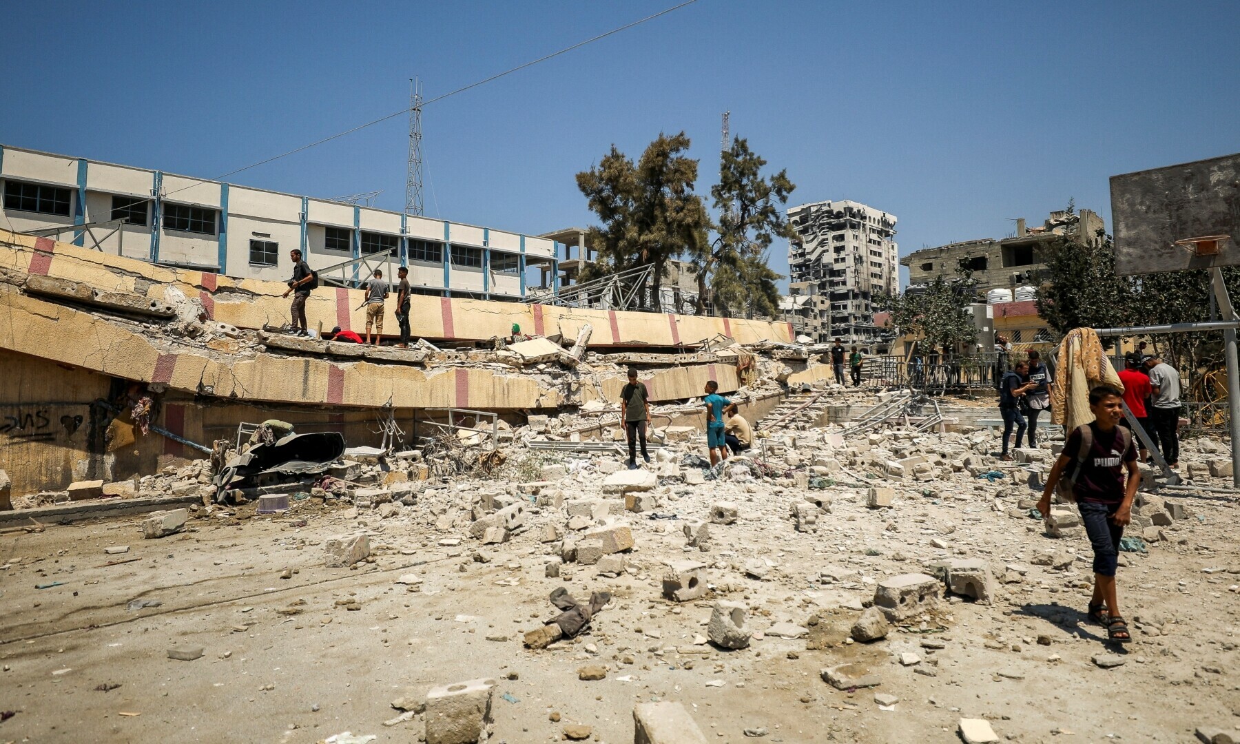  Palestinians inspect a school sheltering displaced people after it was hit by an Israeli strike, in Gaza City, on Aug 20, 2024. &mdash; AFP 