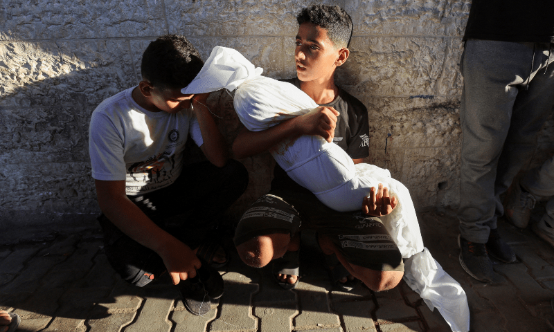  A cousin of a Palestinian child killed in an Israeli strike holds the body, in Deir Al-Balah in the central Gaza Strip, on Aug 20, 2024. &mdash; Reuters 