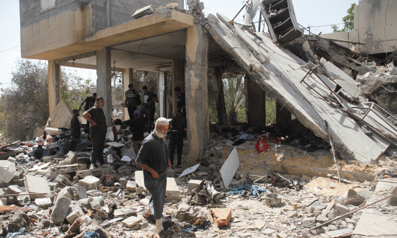  Palestinians stand at the site of an Israeli strike on a house in Beit Lahia in the northern Gaza Strip on Aug 22, 2024. &mdash; Reuters 
