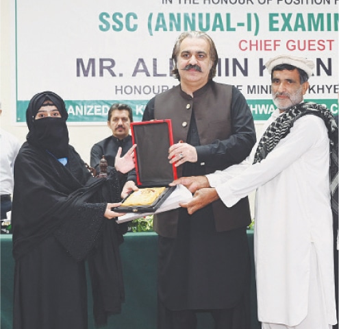 KP Chief Minister Ali Amin Gandapur awards a souvenir to a position holder in SSC exam at a ceremony in Peshawar on Thursday. — Dawn