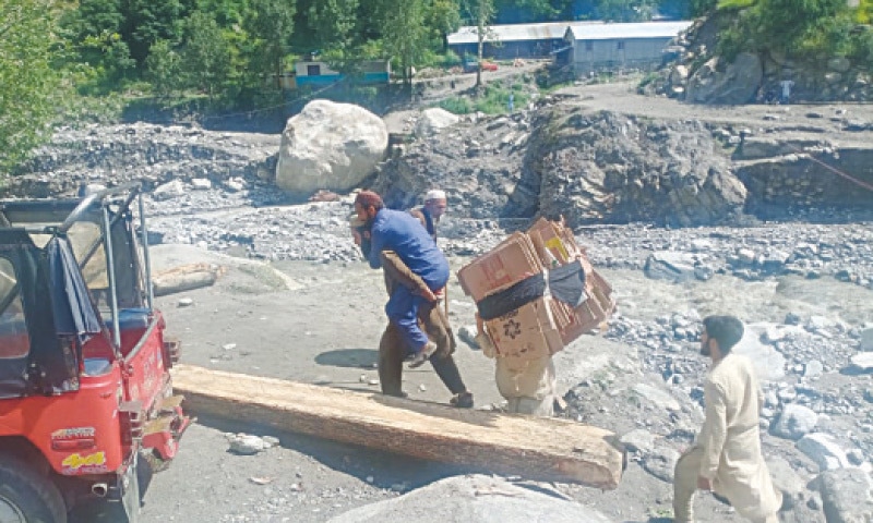 A man carries a patient to a health facility in Bala Manor area of Mansehra on Saturday. &mdash; Dawn photo