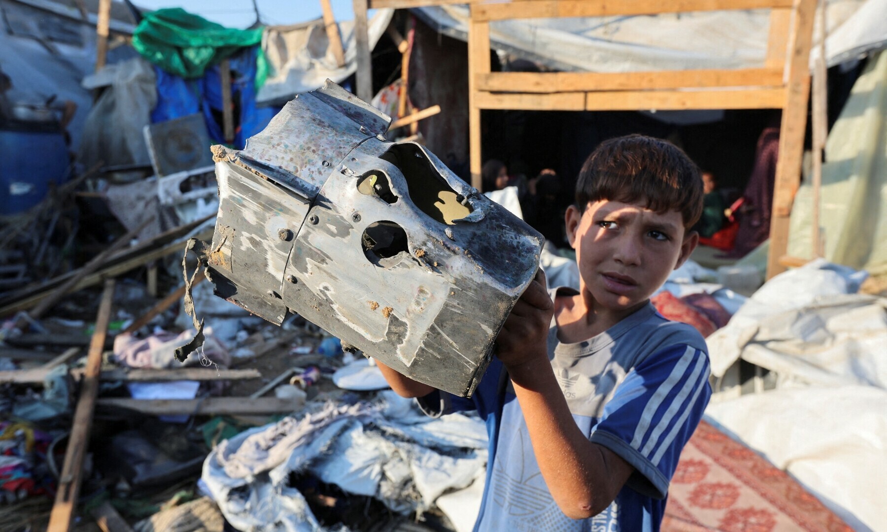  A Palestinian child holds the remains of a missile at the site of an Israeli strike on the courtyard of Al-Aqsa Martyrs hospital, where displaced people were taking shelter in tents in Deir Al-Balah in the central Gaza Strip, on Sept 5, 2024.&mdash; Reuters/Ramadan Abed 
