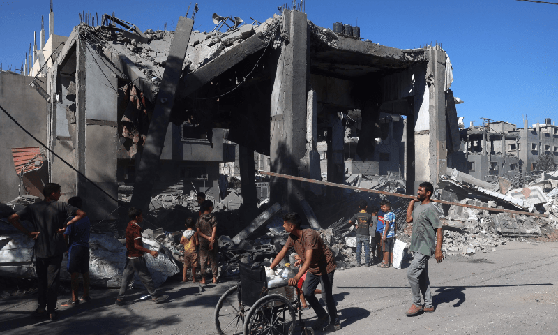  Palestinians walk past a mosque after it was hit in an Israeli strike in the Bureij refugee camp in central Gaza Strip on Sept 11, 2024. &mdash; Eyad BABA / AFP 