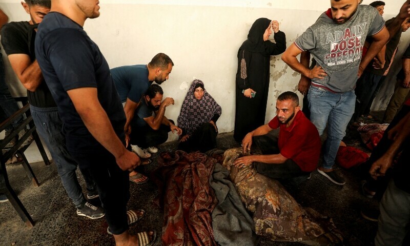 Palestinian gather next to bodies, after a school that was sheltering displaced people was hit by an Israeli strike, amid the Israel-Hamas conflict, at a hospital in Gaza City, September 21. &mdash; Reuters
