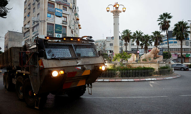A military vehicle moves in a street outside the building where the Al Jazeera office is located, in Ramallah, in the Israeli-occupied West Bank, September 22. &mdash; Reuters