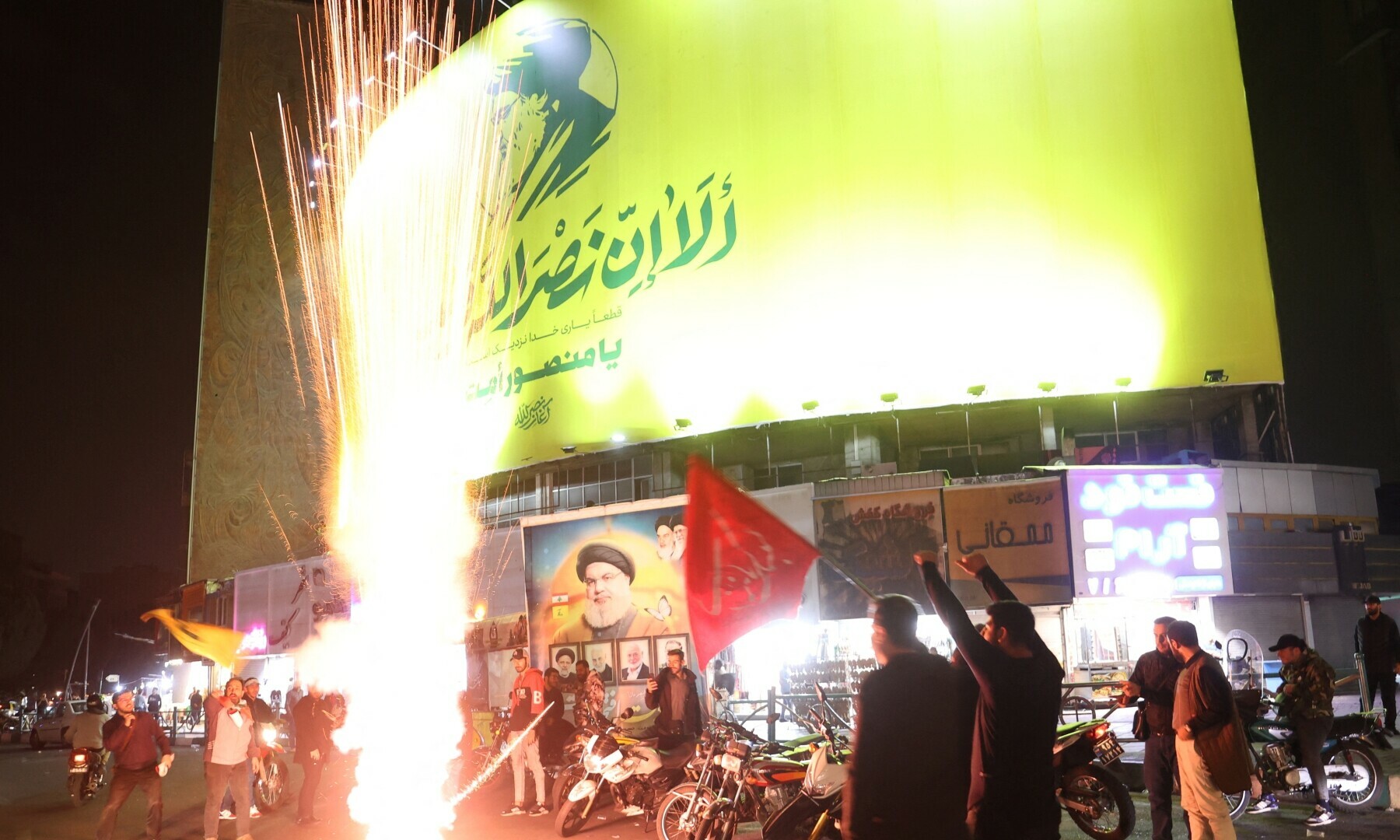  Iranians light fireworks next to a billboard with a picture of the late Lebanon&rsquo;s Hezbollah leader Sayyed Hassan Nasrallah, after the IRGC attack on Israel, in Tehran, Iran on Oct 1, 2024. &mdash; Wana via Reuters 
