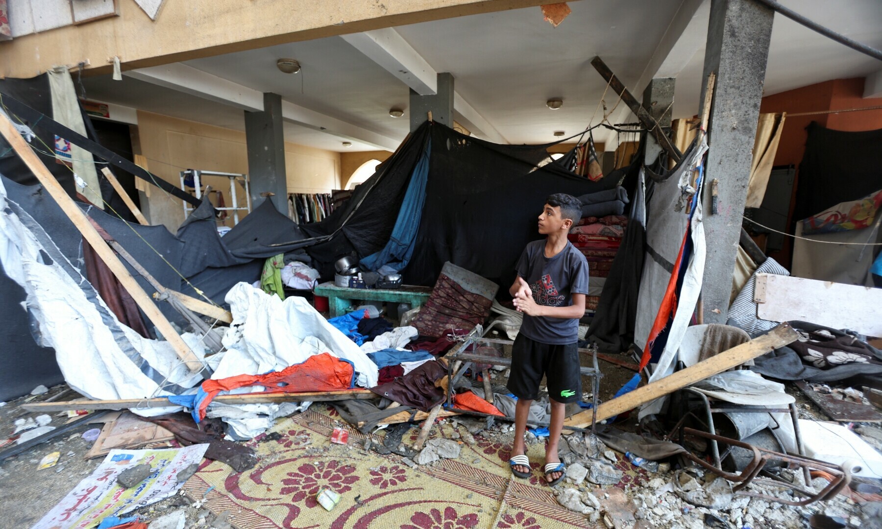 A Palestinian boy stands at the site of an Israeli strike on a school sheltering displaced people, in Deir Al-Balah in the central Gaza Strip, on Oct 10, 2024. — Reuters