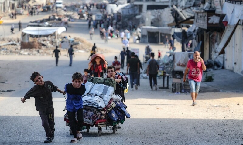 Palestinians carry their belongings as they flee areas north of Gaza City in the northern Gaza Strip on October 12. &mdash; AFP