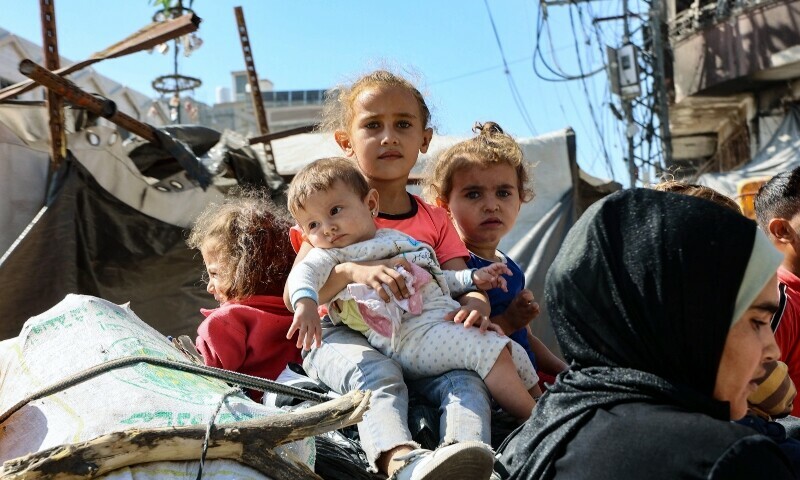 Palestinian children sit atop their family&rsquo;s belongings as they flee areas north of Gaza City in the northern Gaza Strip on October 12. &mdash; AFP