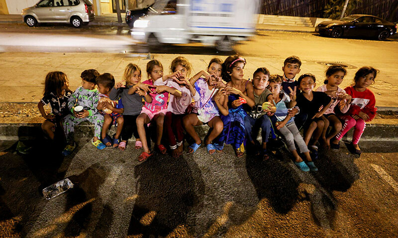 Displaced children sit on a sidewalk in Beirut’s central Martyrs’ Square on October 30. — Reuters