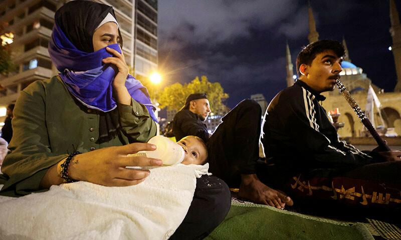 Displaced families sit on the street in Beirut’s central Martyrs’ Square, where many families spend the night fleeing the ongoing Israeli strikes in southern Beirut, in Lebanon on October 30. — Reuters